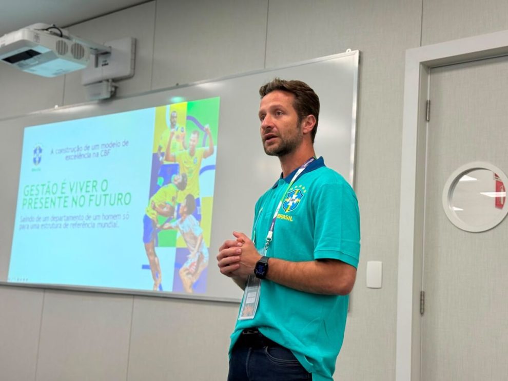 Os fisioterapeutas maringaenses Kleber Barbão e Valter Rovere participaram, nesta semana, do Workshop de Integração das Seleções Brasileiras de Futsal e Beach Soccer, promovido pela Confederação Brasileira de Futebol (CBF), na Granja Comary, em Teresópolis, RJ. O encontro reuniu 63 profissionais que integram as comissões técnicas das seleções masculinas e femininas, tanto das categorias de base quanto das equipes principais de futsal e beach soccer. O workshop teve como objetivo unificar métodos e procedimentos de trabalho, além de promover debates técnicos e a troca de experiências entre os profissionais que atuam diariamente nas seleções brasileiras. Referência nacional na fisioterapia esportiva, Kleber Barbão integra a comissão técnica da Seleção Brasileira Principal de Futsal desde 2013, participando de importantes conquistas da modalidade ao longo da última década. Já Valter Rovere é o fisioterapeuta responsável pela Seleção Brasileira Masculina Sub-20 de Futsal, acompanhando o desenvolvimento das principais promessas do esporte no país. Além do trabalho junto à CBF, os dois profissionais são maringaenses e fazem parte da equipe da Clinisport Prime, empresa referência em reabilitação, fisioterapia e performance esportiva. Ambos também acumulam passagens por importantes equipes do futsal e do futebol de campo brasileiro, além de atendimento pontual a atletas de alto nível, consolidando suas trajetórias no esporte de alto rendimento. Para Kleber Barbão, momentos como esse fortalecem ainda mais o trabalho realizado dentro das seleções e trazem aprendizados para o dia a dia. "É uma oportunidade muito importante para alinharmos processos, compartilharmos experiências e discutirmos a evolução da nossa área. Cada profissional traz uma vivência diferente e isso enriquece o trabalho de todos. Ao mesmo tempo em que aprendemos, também temos a oportunidade de transmitir um pouco da experiência acumulada ao longo dos anos dentro da Seleção Brasileira e de outros trabalhos. Além, claro, de trazer mais aprendizados para nossos atendimentos no dia a dia", destacou. Valter Rovere também ressaltou a importância da integração entre os profissionais que atuam nas diferentes categorias. "Esses encontros aproximam as comissões técnicas e permitem que exista uma continuidade metodológica entre as categorias de base e a seleção principal. Além disso, poder dividir experiências, discutir casos e conhecer diferentes formas de atuação contribui diretamente para a evolução profissional de todos nós", afirmou. A programação do Workshop de Integração do Futsal e Beach Soccer contou ainda com um tour pelas instalações da Granja Comary e momentos de interação entre os profissionais das modalidades e integrantes das comissões técnicas das seleções brasileiras de futebol de campo, ampliando a troca de conhecimento entre diferentes áreas do esporte de alto rendimento. A presença de dois profissionais maringaenses em um encontro estratégico da CBF reforça a qualidade dos especialistas formados e atuantes na cidade e região, levando o nome de Maringá ao cenário nacional e contribuindo diretamente para o desenvolvimento das seleções brasileiras.